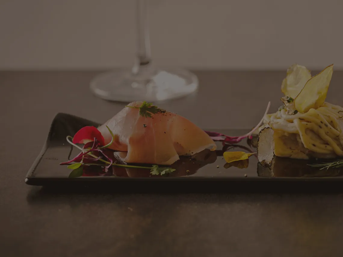 EX dish on a dark plate with a glass